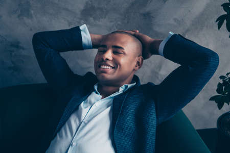 Close-up portrait of his he nice classy attractive dreamy cheery guy wearing jacket white collar executive manager having rest time at workplace station gray concrete wall.の写真素材
