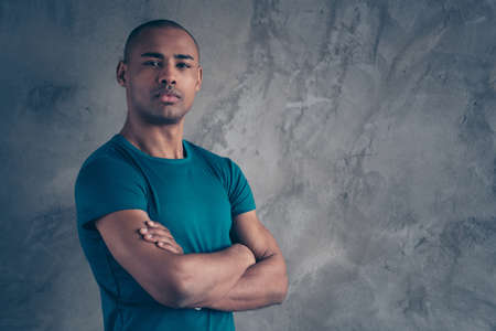 Profile side view portrait of his he nice attractive muscular sportive strong powerful bossy guy wearing trendy blue t-shirt folded arms isolated over gray industrial concrete wall.の写真素材