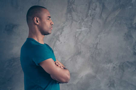 Profile side view portrait of his he nice-looking attractive strong character feature content guy wearing trendy blue t-shirt isolated over gray industrial concrete wall.の写真素材