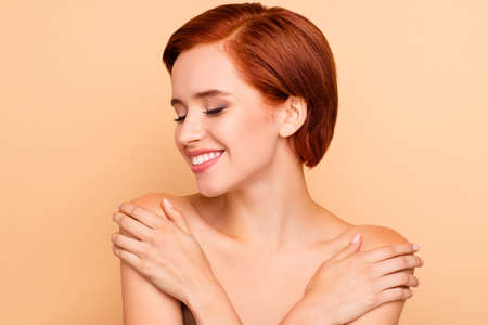 Close-up portrait of nice lovely sweet winsome delicate attractive charming dreamy girl pure smooth clean clear perfect shine flawless fresh skin touching shoulders isolated over beige backgroundの写真素材