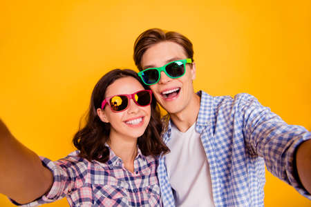 Close up photo of pair in love he him his she her lady boy after wedding going to honeymoon take make first photos wearing casual plaid shirt outfit isolated on yellow backgroundの写真素材
