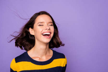Close up photo beautiful amazing funky she her lady enjoy warm wind pretty overjoyed impressed hairstyle flight eyes closed wear blue yellow striped pullover isolated violet purple backgroundの写真素材