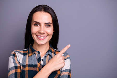 Close-up portrait of her she nice-looking lovely attractive cheerful cheery straight-haired lady wearing checked plaid pointing one forefinger aside ad isolated on gray violet purple pastel backgroundの写真素材