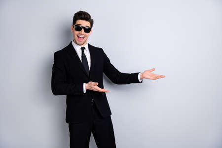 Stylish product concept. Portrait handsome smart real estate agent advise decide give information ad suggest excited content candid enjoy isolated grey background specs eyewear eyeglasses outfitの写真素材