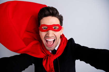 Close up photo adventurous facial expression he him his man flying use superpower make take selfies wear red long cloak raised wind safety protection human comics character isolated grey backgroundの写真素材