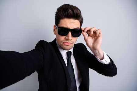 Close up photo amazing he him his macho handsome make take selfies chief expression pretend men in black character funny funky wear specs shirt suit jacket tie formalwear isolated grey backgroundの写真素材