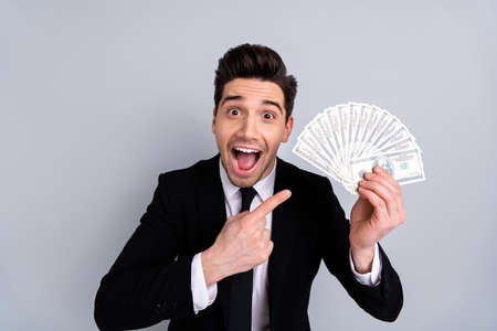 Close-up portrait of his he nice attractive cheerful ecstatic guy economist auditor boss accountant holding in hand sum banknote lottery cashback withdrawal isolated over light gray backgroundの写真素材