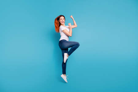 Full length body size profile side view portrait of   nice attractive cheerful cheery ecstatic girl wearing white tshirt celebrate attainment isolated over bright vivid shine blue backgroundの写真素材