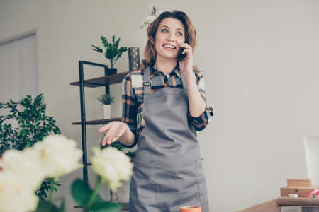 Portrait positive cheerful satisfied excited lady vendor free time dialogue use modern technology...