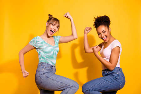 Close up side profile photo beautiful she her lady different nationalities celebrate hands arms fists raised up yell amazed wear casual white striped t-shirt clothes isolated yellow bright backgroundの写真素材