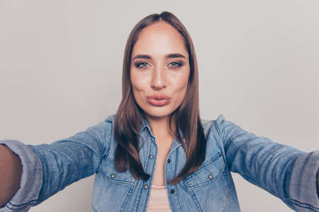Self-portrait of nice-looking attractive lovely winsome gorgeous fascinating cheerful cheery straight-haired lady sending air blow kiss coquette isolated over light white gray background.の写真素材