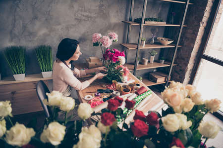 Above high angle view of her she nice attractive lovely charming concentrated hard-working wavy-haired lady employee creating making bunch birthday garden grey concrete wall workplaceの写真素材