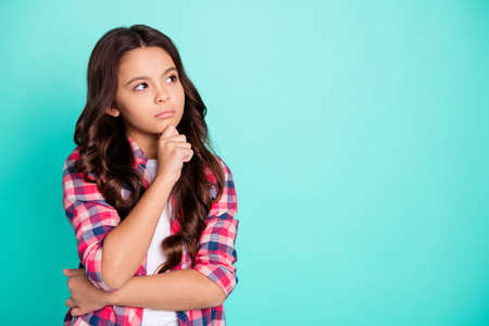 Portrait of nice attractive concentrated minded kid touch chin solve troubles study education genius future academic choice decision dressed plaid modern outfit isolated turquoise background.の写真素材