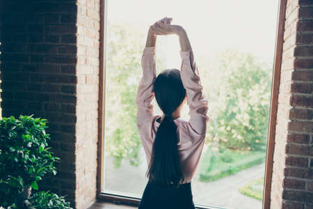 Rear back behind view of her she nice attractive chic stylish lady company director stretching at modern industrial loft interior style work place station indoors.の写真素材