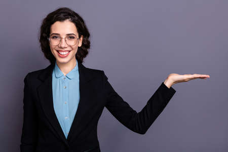 Portrait of charming gorgeous entrepreneur excellent choice decision advertise real promoter dressed black blazer jacket wavy curly hairstyle hairdo isolated grey backgroundの写真素材