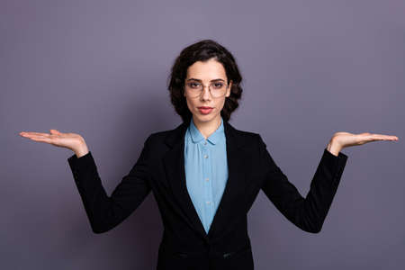 Portrait of gorgeous entrepreneur focused concentrated pensive ready promote choose decide advise advice wavy curly hairdo isolated grey background round specs classy blazerの写真素材