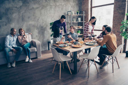 Close up photo friendly talk conversation company pairs birthday event different race guys glasses beverage sit table couch sofa shirts formal-wear sweater pullover loft room cafe restaurant indoorsの写真素材
