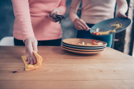Cropped close up photo two people she her ladies arms hold dirty plates clean wash table wet rag...