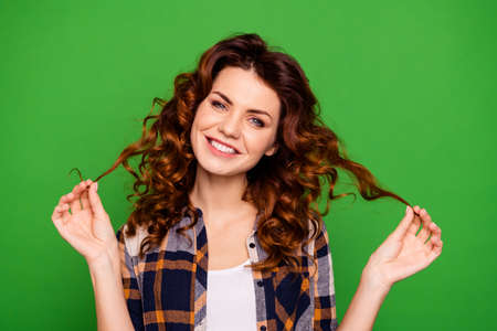 Close-up portrait of her she nice-looking attractive lovable lovely pretty cheerful cheery dreamy wavy-haired lady touching curls isolated over bright vivid shine green backgroundの写真素材