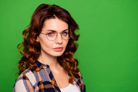 Close-up portrait of her she nice lovely lovable winsome pretty attractive serious candid nerd wavy-haired girl wearing formal checked shirt isolated on bright vivid shine green backgroundの写真素材