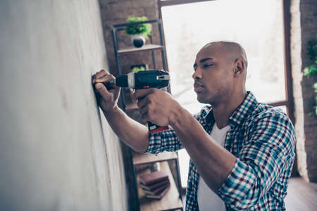 Profile side view photo of focused charming use user electronic machine technician professional skilled stand room apartment wear checked plaid shirt handsomeの写真素材
