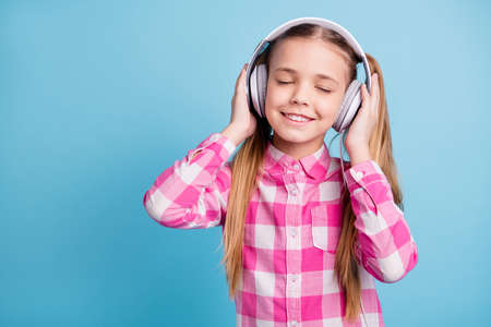 Close up photo beautiful amazing she her little lady weekend vacation mood ear flaps headset listen favorite playlist eyes closed wear casual checkered plaid pink shirt isolated bright blue backgroundの写真素材