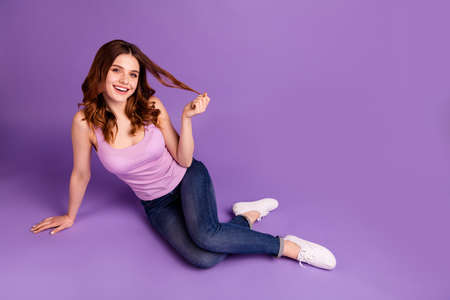 Portrait of attractive lady touch haircut hairdo feel glad content flirt flirty, laughter dressed fashionable singlet modern outfit she her isolated lie purple violet background brightの写真素材