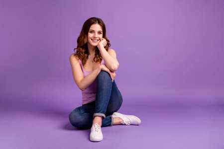 Portrait of cute pretty lady touch hands palms cheeks face dressed, singlet clothing modern fashionable isolated contemplate thoughtful imagine purple violate she her backgroundの写真素材