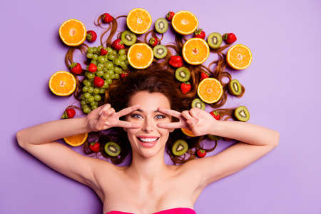 Close-up portrait of her she nice attractive lovely well-groomed perfect charming cheerful cheery feminine wavy-haired lady showing v-sign vitamin party isolated over violet purple backgroundの写真素材