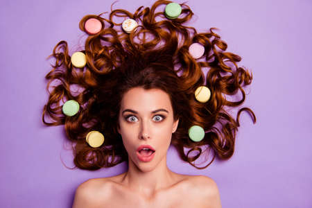 Close-up portrait of her she nice-looking charming cute attractive lovely cheerful amazed nude naked lady with macaroons in hairdo hairdress isolated over violet purple pastel backgroundの写真素材