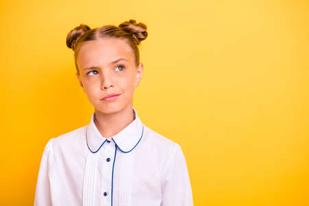 Close-up portrait of her she nice-looking attractive lovely moody doubtful pre-teen girl wearing white shirt solving task isolated on bright vivid shine yellow backgroundの写真素材
