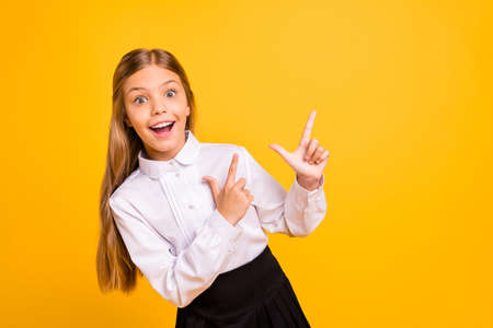 Close-up portrait of nice attractive confident glad cheerful straight-haired pre-teen girl pointing aside advert tips feedback sale discount solution isolated over bright vivid shine yellow backgroundの写真素材