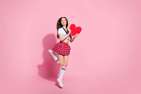 Full length body size view of her she nice-looking attractive charming lovely slim cheerful cheery straight-haired lady having fun holding in hands large heart isolated on pink pastel backgroundの写真素材