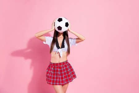 Photo of faceless lady cheerleader hold hands hide face soccer ball wear red short skirt white top isolated pink backgroundの写真素材