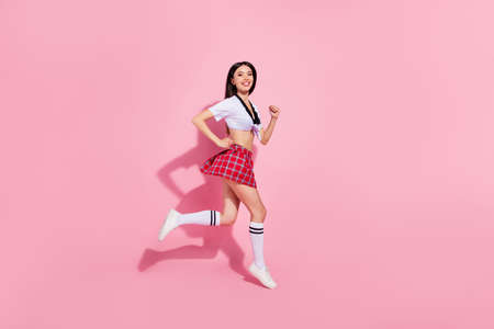 Profile side full length body size view of her she nice-looking attractive charming cheerful cheery straight-haired lady having fun running fast isolated over pink pastel backgroundの写真素材