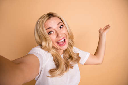 Portrait of charming funky lady make photos travel holiday free time isolated on beige backgroundの写真素材