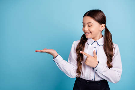 Portrait of nice child have promotion choice decision isolated over blue backgroundの写真素材