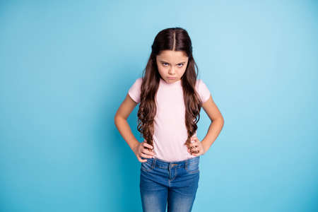 Portrait of disappointed kid have offense ignore no communication hands palms on waist hips frown wear jeans modern pastel-colored clothes isolated on blue backgroundの写真素材