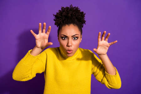 Close up photo of scary beautiful, teenager scream shout boo raise hands showing palms isolated over...