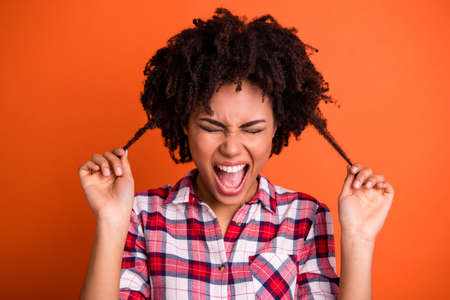 Close-up portrait of her she nice attractive crazy frustrated depressed wavy-haired lady holding weak thin messy curls solution isolated on bright vivid shine orange backgroundの写真素材