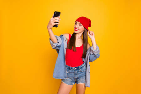 Portrait of charming lady make photos device gadget video calling travel trip isolated over yellow backgroundの写真素材