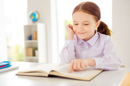 Close up photo of adorable focused concentrated kid have materials fantasy book white blouse shirt...