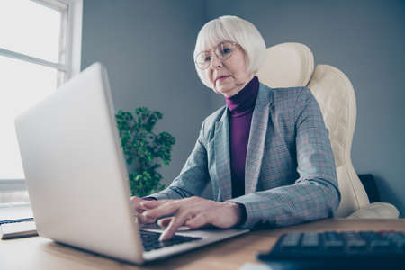 Photo of aged business lady head organization writing report sit big chair notebook table wear specs plaid costume jacketの写真素材