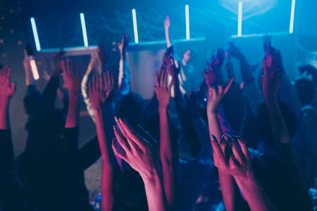 Cropped view photo blurred of large group people raise hands enjoy disco discotheque dance floorの写真素材