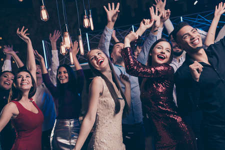 Close up photo of cute charming buddies people funny funky raise hands dance floor discotheque indoors free time cheerfulの写真素材