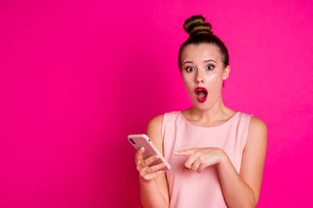 Portrait of cute funny funky teen teenager astonished impressed wonderful novelty information hold hand blog blogger dressed she her outfit top-knot isolated pink backgroundの写真素材