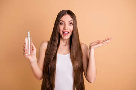 Portrait of cute pretty teenager, hold hand have procedure medical health care conditioner cleansing moituriser wear top signlet white colored isolated beige backgroundの写真素材