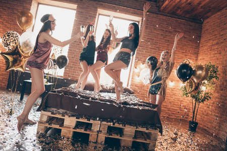 Full length body size view of nice cool sweet attractive winsome lovely slim fit thin slender cheerful cheery glad group having fun time raising hands up in loft industrial brick style interior roomの写真素材