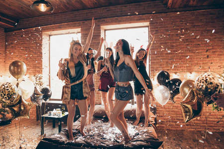 Full length body size view of nice attractive feminine lovely royal cheerful group having fun dancing on bed birthday in open space golden decorated loft industrial style interior roomの写真素材