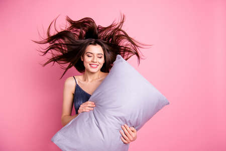 Portrait of her she nice-looking sweet attractive lovely charming pretty cheerful cheery straight-haired lady holding in hands pillow isolated over pink pastel backgroundの素材 [FY310127384631]